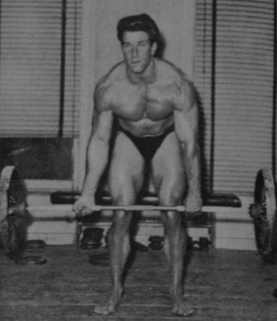Reg Park performing the deadlift exercise off a pair of boxes.